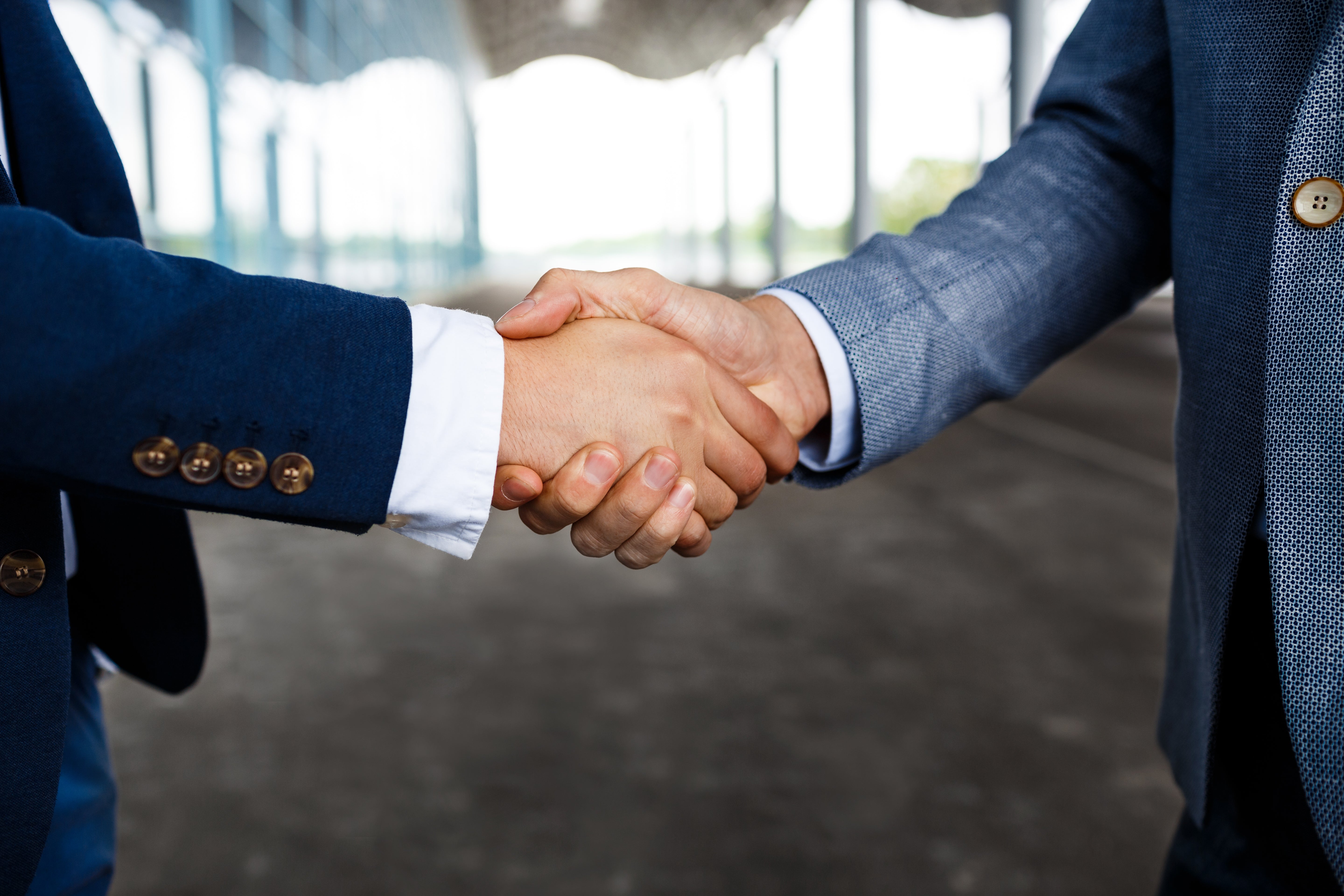 Two businessmen shaking their hands representing the corporate travel partnership.
