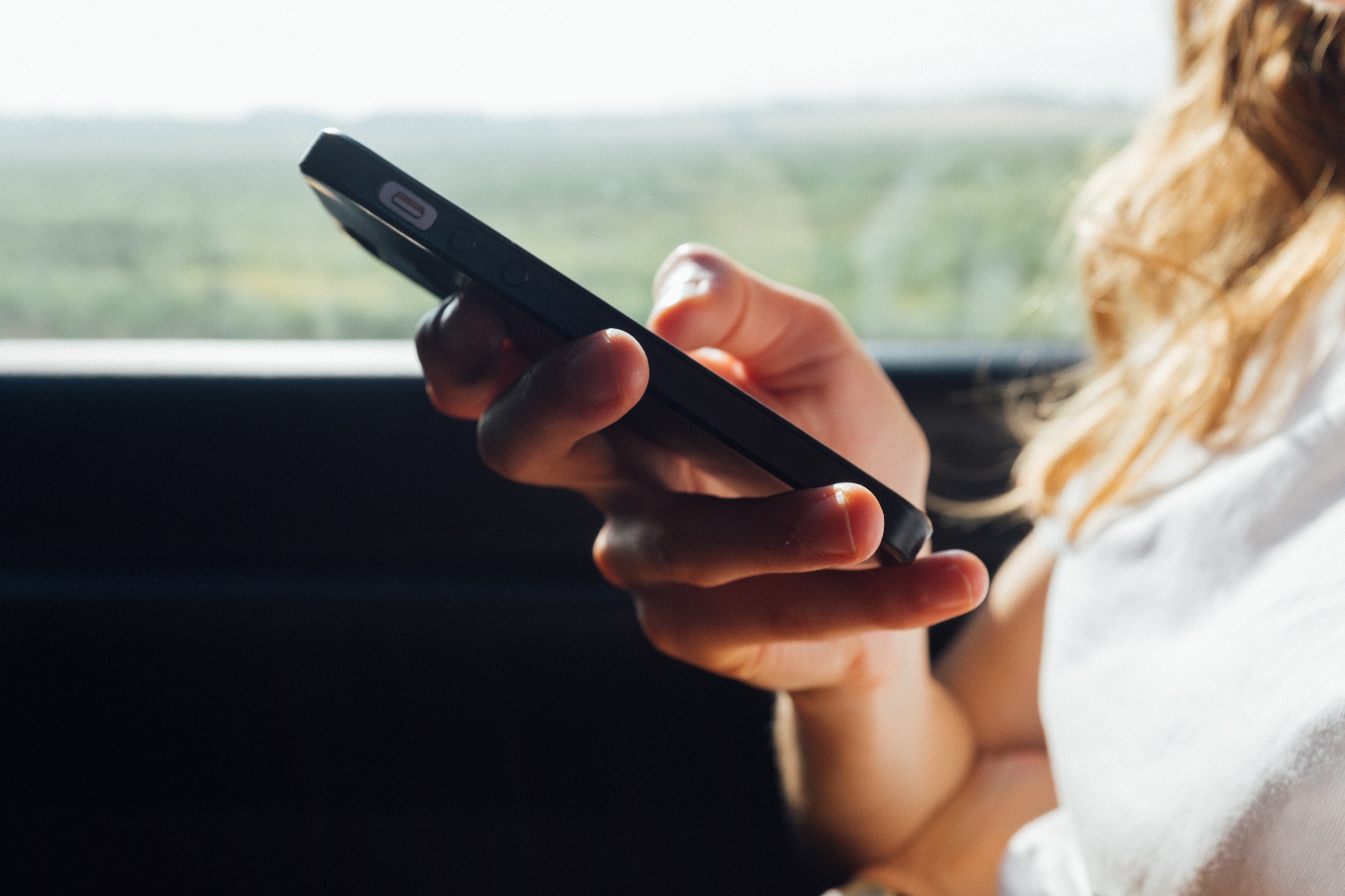 A woman is clicking a button on her phone, representing that she's availing the 100% discount code.