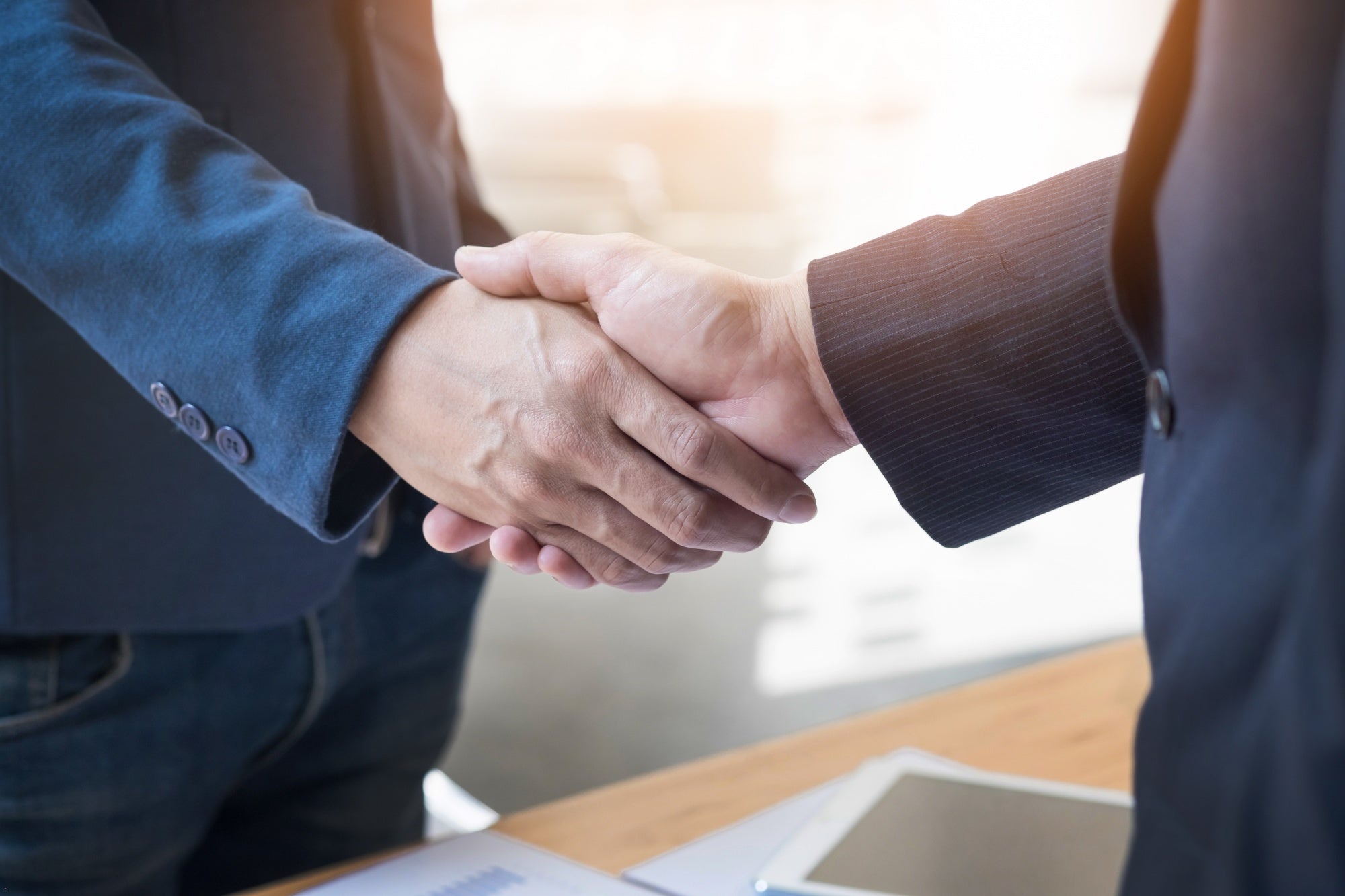 Two guys shake their hands representing a distributor partnership.