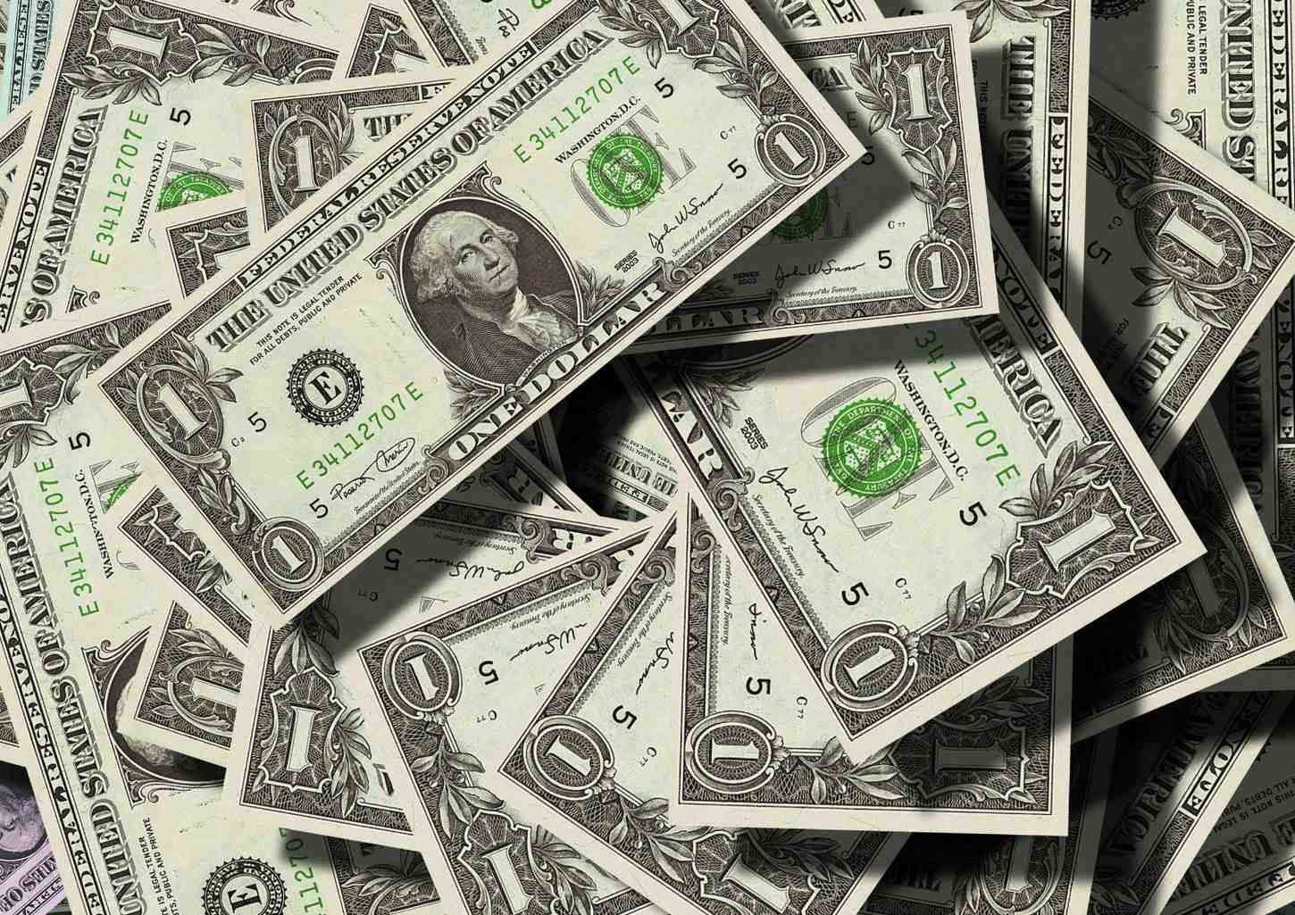 A pile of US dollar bills, symbolizing earnings and revenue that taxi drivers can track on their affiliate dashboard.