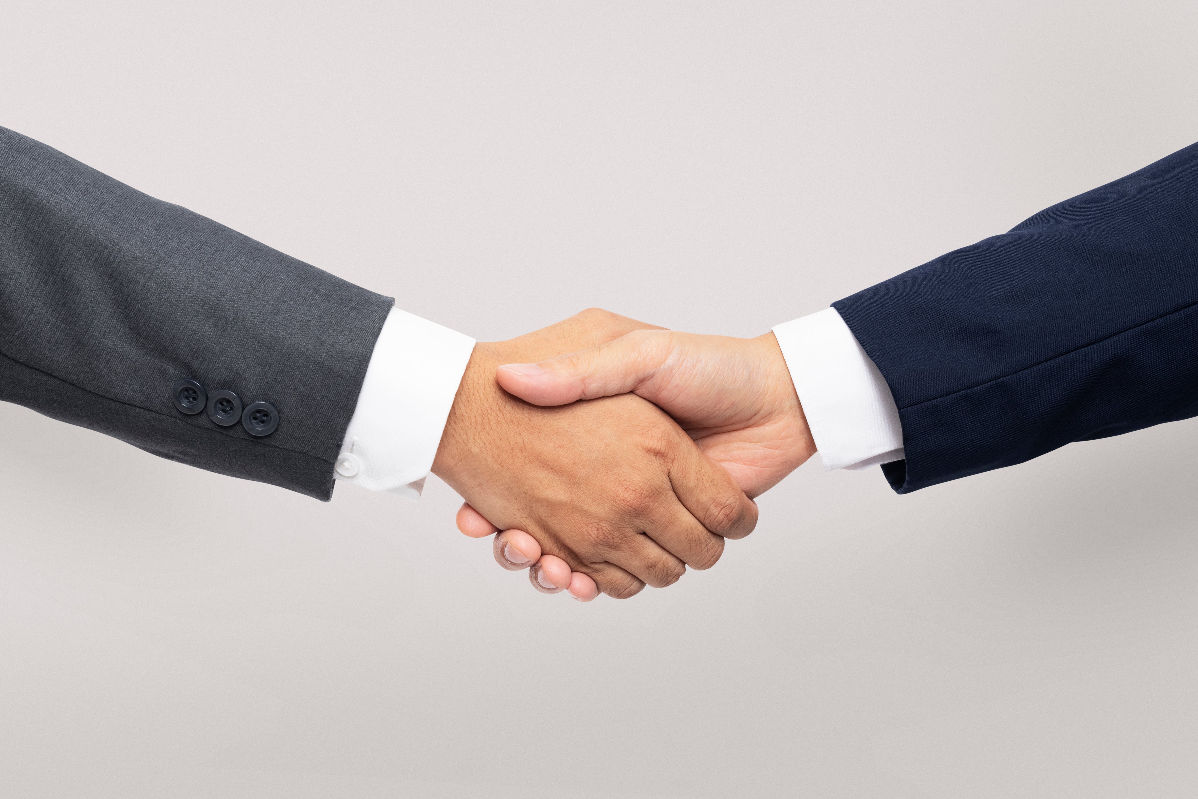 Two businessmen shaking their hands, showcasing that they're partnering to create a white-labeled eSIM store for the partner and offering eSIMs to their customers.