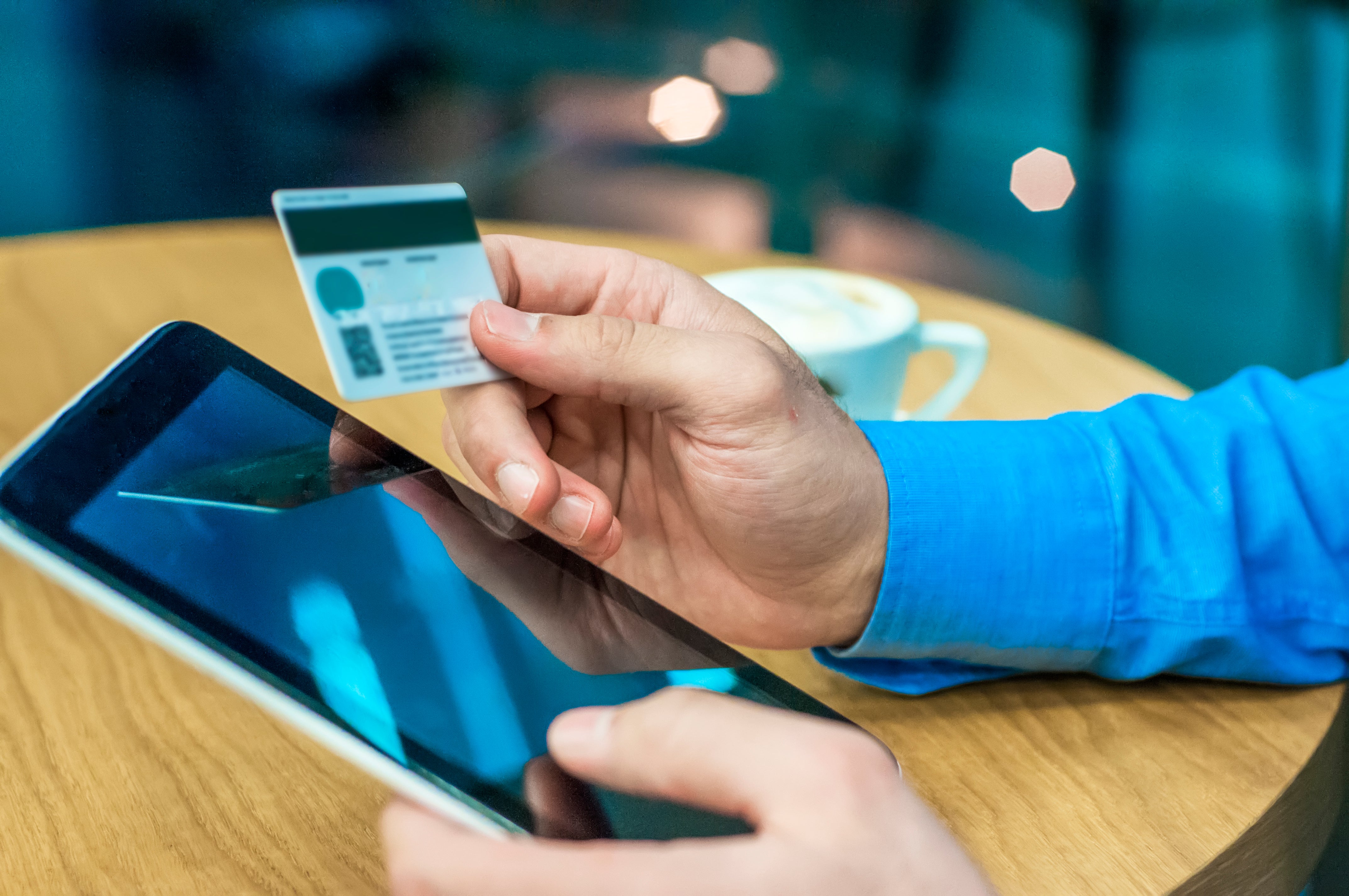 The business holds an tablet and credit card, representing the purchase of eSIMs.